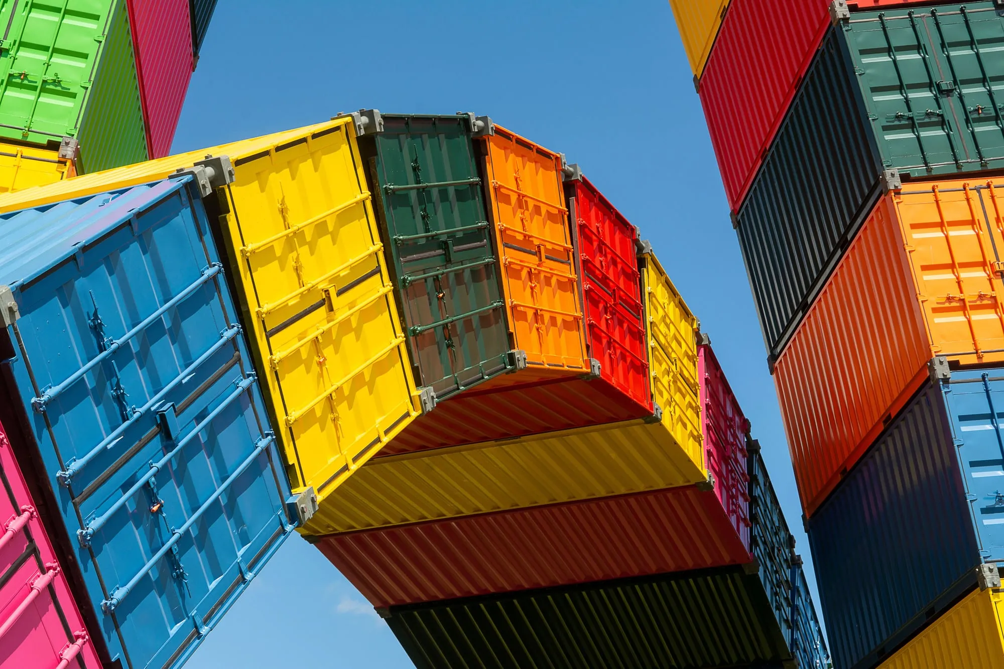 Brightly colored shipping containers stacked against a blue sky